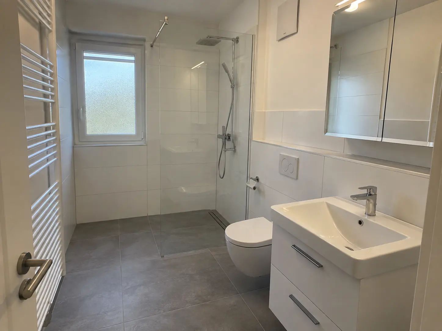 Renoviertes Bad mit bodengleicher Dusche und Glaswand