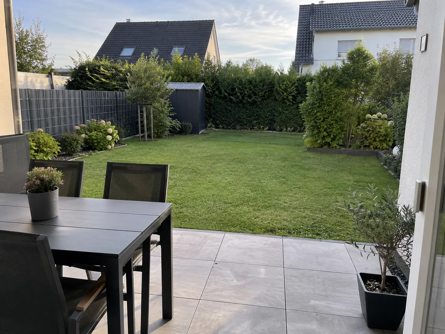 Blick von der Terrasse mit Esstisch in den eigenen Garten