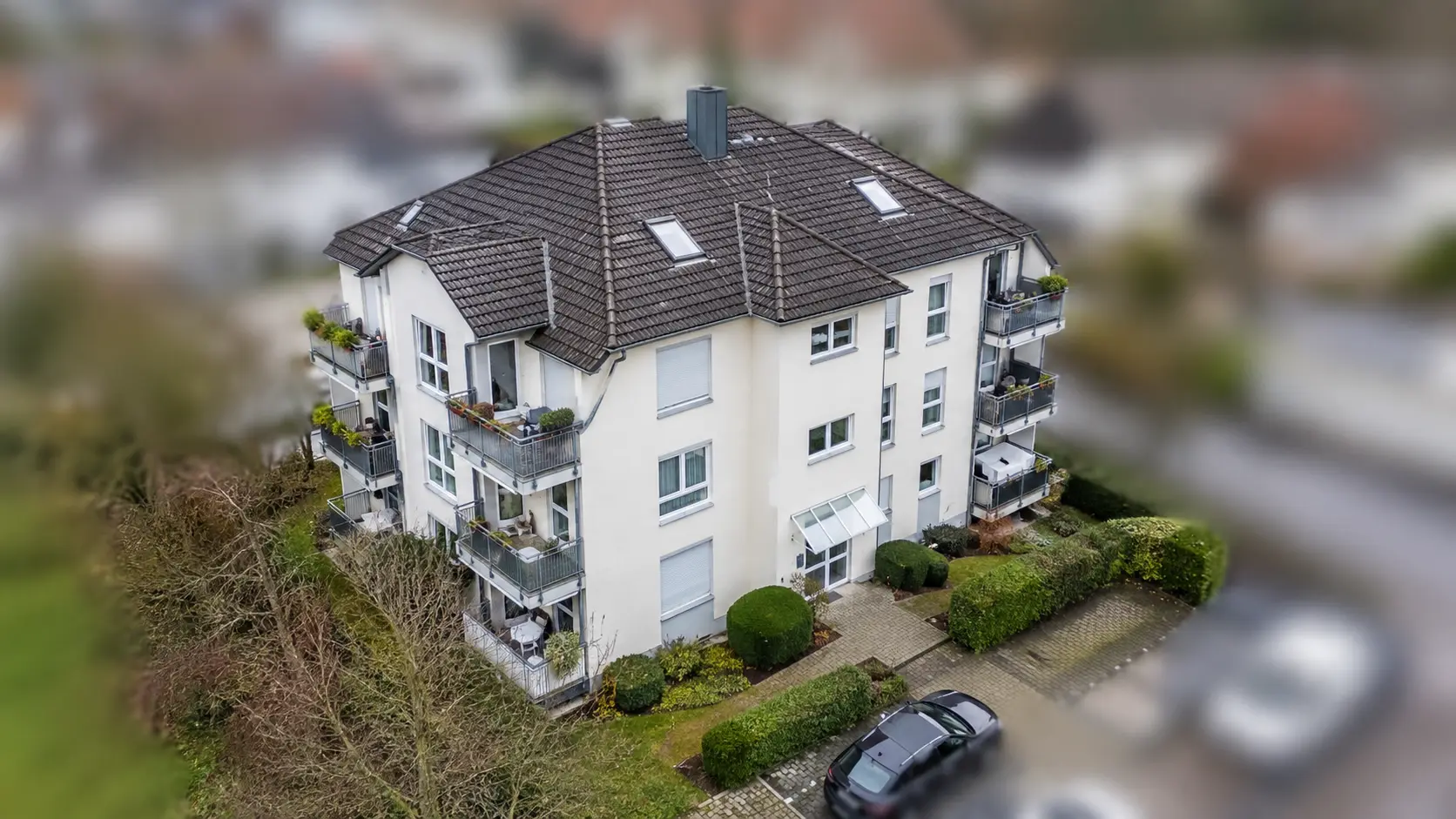 Neues Mehrfamilienhaus mit Balkonen und Garten von oben