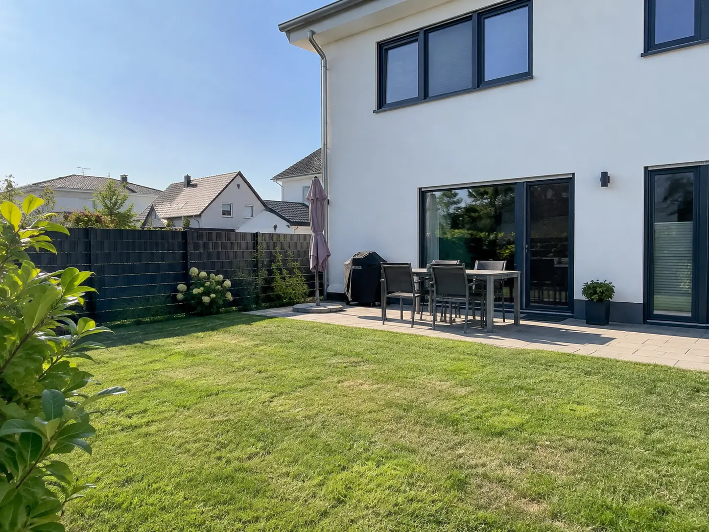 Garten mit Terrasse und Sitzgruppe an einem modernen Haus